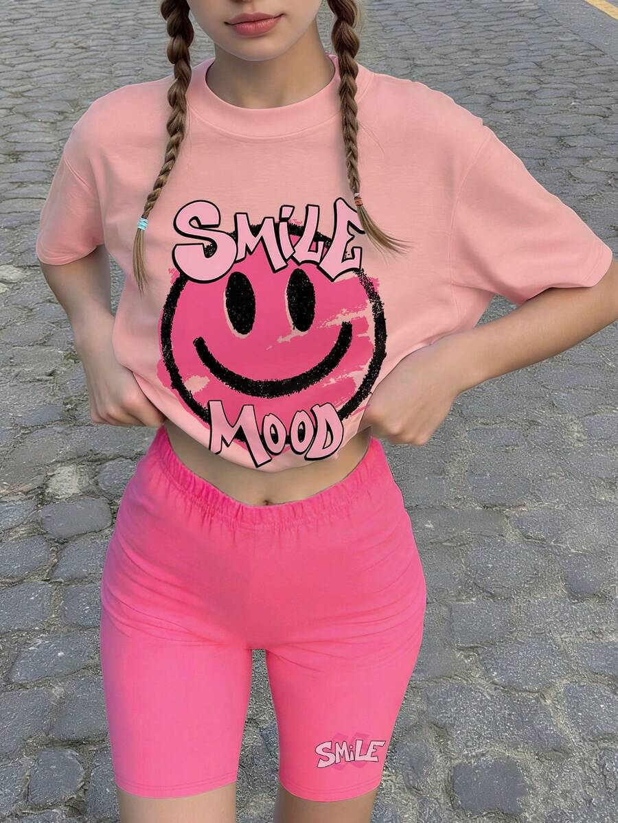 Bộ đồ 2 món cho bé gái với họa tiết mặt cười, áo thun hồng graffiti hình mặt cười và quần short biker, phong cách đường phố Y2K mùa hè, thích hợp cho hoạt động trượt ván và đi chơi. - Hồng - Xem 1
