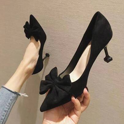 Zapatos de tacón alto de punta afilada estilo francés para mujer con detalle de lazo. Zapatos de trabajo profesionales de tacón de aguja y punta abierta a la moda en color negro.