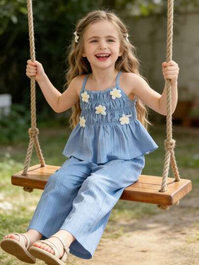 这款女童无袖吊带连衣裙，露肩设计，饰以白色3D立体花朵，更添甜美气息。搭配宽松直筒裤，舒适自在，适合活泼可爱的小女孩穿着。既时尚又不失童趣，轻盈透气的面料，是夏季的理想之选。