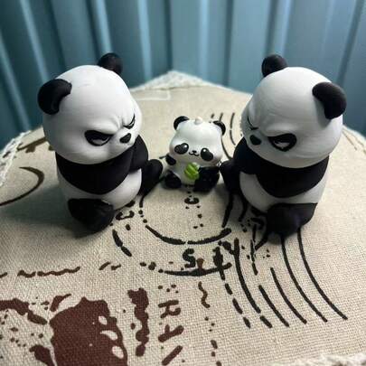 两只活泼的大熊猫，怀抱竹制珍宝，组成了一幅无比温馨的“熊猫群像”。它们标志性的黑白配色和生动的表情完美地展现了国宝的魅力。