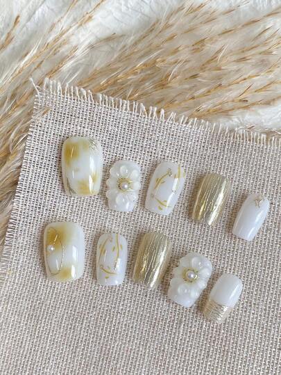 这款美甲套装包含10片手工制作的短方形美甲片。这些美甲片饰有滴胶小花、绿色渐变晕染、不对称线条、仿珍珠和宝石，散发着闪亮的光泽。它们是可轻松取下的按压式美甲产品。