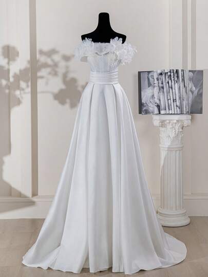 Elegant brudklänning med bar axel, volangdetaljer och pärldekorationer