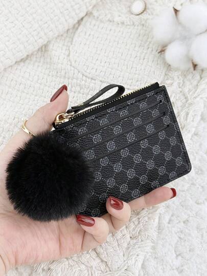这款黑色拉链小钱包带有绒球挂饰，内含零钱袋，对折设计，纤薄轻巧，多层便携，可装身份证、现金、信用卡等，简约时尚，适合商务场合，是周年纪念、生日、送礼的理想之选，也适合送给女孩、女士或女性，是学校宿舍和返校季的必备单品。