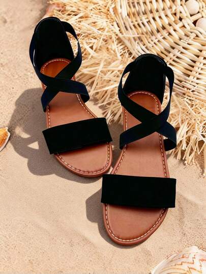 一双青少年露趾凉鞋，交叉弹力带设计，平底防滑，适合户外玩耍和夏季街头穿着。