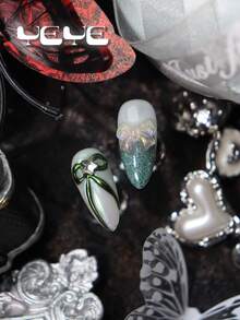 10片杏仁形假指甲，白色底，饰以金属银色和绿色装饰，闪粉点缀，配有透明蝴蝶结、星星水钻装饰和3D立体装饰元素，田园风全覆盖假指甲，亚克力材质，中长款，优雅时尚。套装包含1个迷你指甲锉和1张胶贴，适合女性和女孩使用。适用于日常佩戴、派对、婚礼等场合。手工美甲贴片。 - 白色 - 查看 5