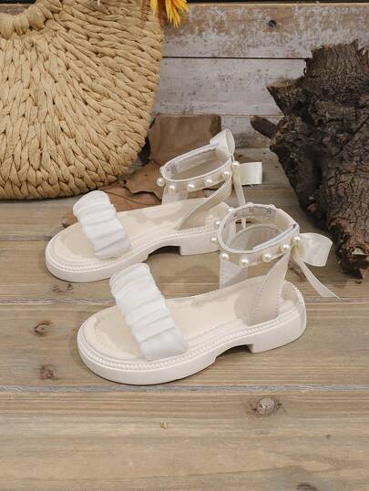 1双白色幼儿/儿童厚底时尚凉鞋，带荷叶边网眼绑带、蝴蝶结珍珠装饰、魔术贴搭扣，简约圆头设计，舒适可爱的罗马风格沙滩凉鞋，适合3-15岁女孩，春夏款。