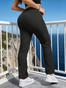 Calça de moletom feminina de corte reto, com cintura elástica minimalista e moderna, bolso lateral com zíper contrastante, ideal para atividades ao ar livre e uso diário. - Preto - Ver 7