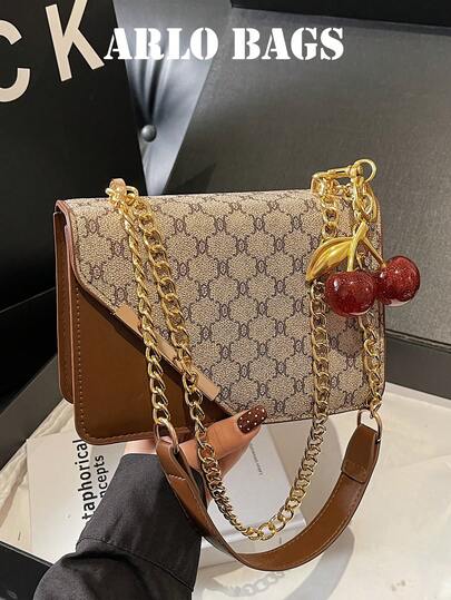 这款时尚百搭的棕色单肩包，饰以红色樱桃吊坠，散发着少女的甜美气息。包身采用双磁扣设计，顶部配有金属链条，可单肩背、斜挎或手提。内部空间足以容纳口红、钥匙、化妆品和其他日常必需品，非常适合女孩通勤上班、购物、约会或日常使用。