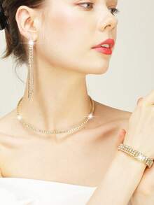 这款镶钻首饰套装包含项链、耳环和手链，搭配镀金亚克力手拿包，适合浪漫婚礼、春夏链条单肩包、新娘包、正式舞会手拿包、优雅晚礼服包，完美适用于派对、婚礼、舞会、晚宴/宴会，可搭配节日派对礼服、晚礼服和亮片连衣裙。 - 金色 - 查看 3