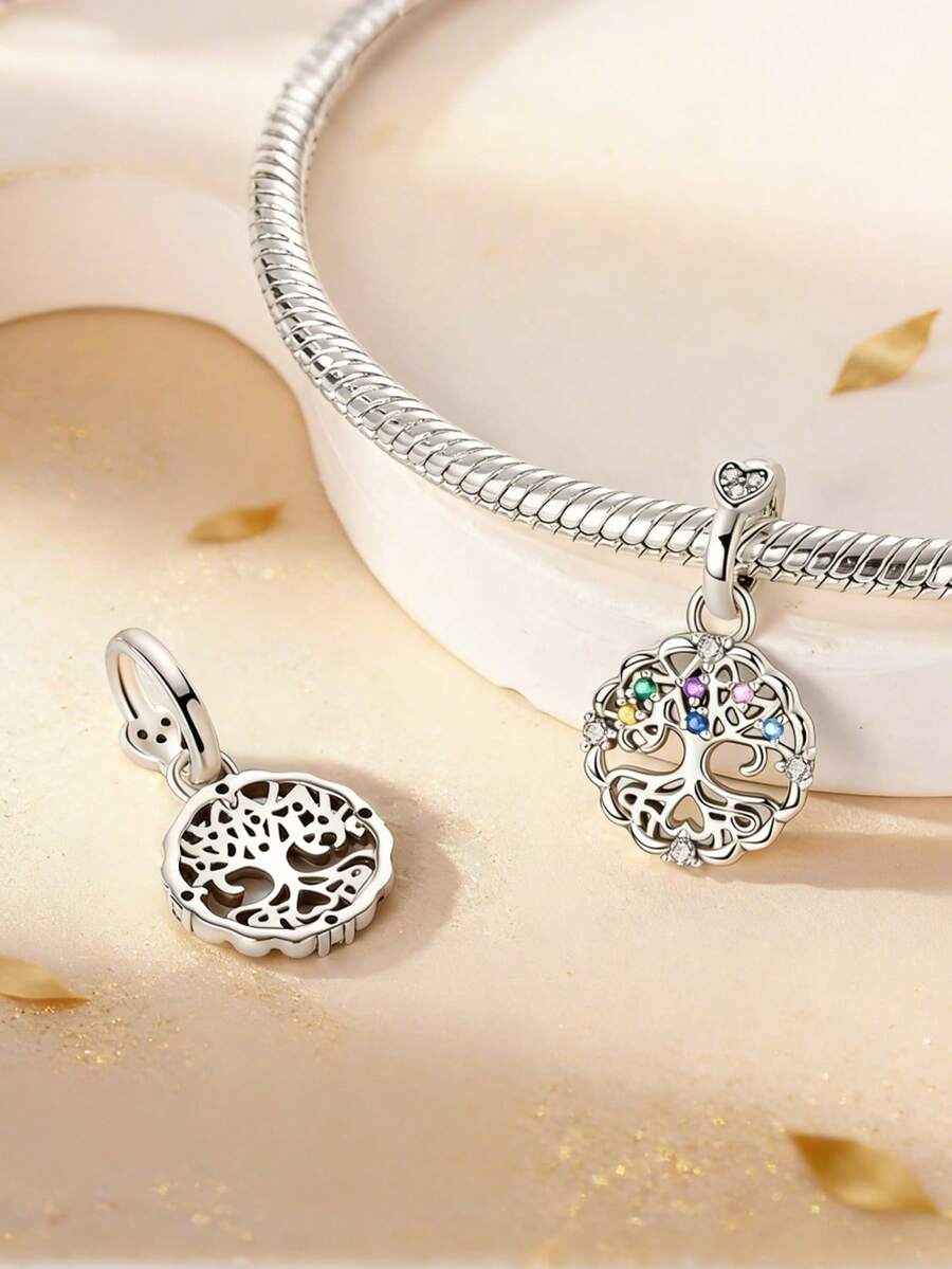 这款精美的925纯银生命之树吊坠，造型别致，经久耐用，触感光滑舒适。其精巧的镂空设计上镶嵌着璀璨夺目的手工镶嵌彩色立方氧化锆石，闪耀着粉色、蓝色、绿色和透明的光芒。