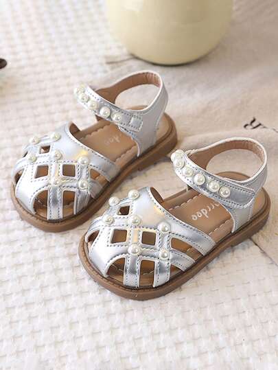 Dép xăng đan kín mũi mới cho bé gái, thiết kế hoa rỗng đính nơ và ngọc trai dễ thương, đế mềm chống trơn trượt, thích hợp cho mùa hè.