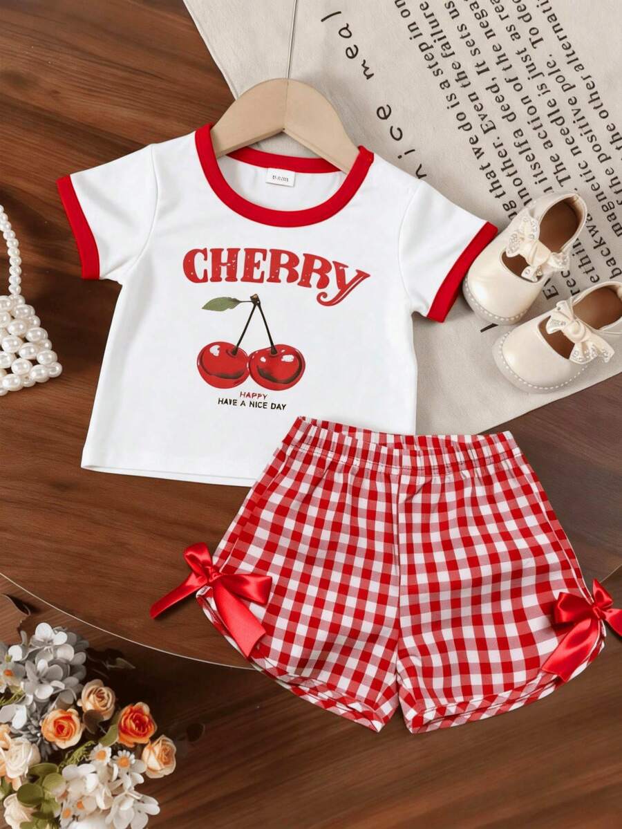 Bộ đồ thường ngày cho bé gái gồm áo ngắn tay cổ tròn in hình quả anh đào và quần short kẻ caro có nơ. - trắng - Xem 1