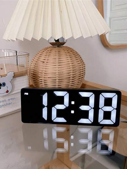 Un reloj despertador digital LED de una sola pieza con un extremo de espejo, que presenta una pantalla digital que puede cambiar entre formatos de 12 y 24 horas.  Este reloj de noche tiene brillo ajustable y funciona silenciosamente, sin batería.