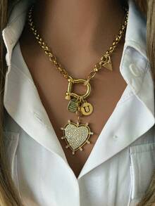 1件女士金项链，采用光滑的马蹄形扣设计，搭配字母、三角形和心形吊坠，设计细节丰富，时尚休闲，可搭配白衬衫。 - 金色 - 查看 17