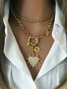 1件女士金项链，采用光滑的马蹄形扣设计，搭配字母、三角形和心形吊坠，设计细节丰富，时尚休闲，可搭配白衬衫。 - 金色 - 查看 1