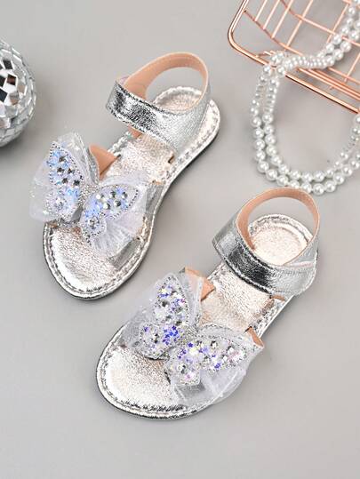 Một đôi sandal đế bằng hở mũi, quai cài, kiểu dáng mới năm 2026 dành cho bé gái, làm bằng lụa lưới, đính đá lấp lánh hình bướm, có sequin óng ánh | Thích hợp cho các chuyến đi chơi cuối tuần cùng gia đình / Tiệc trà chị em / Hoạt động ở trường mẫu giáo
