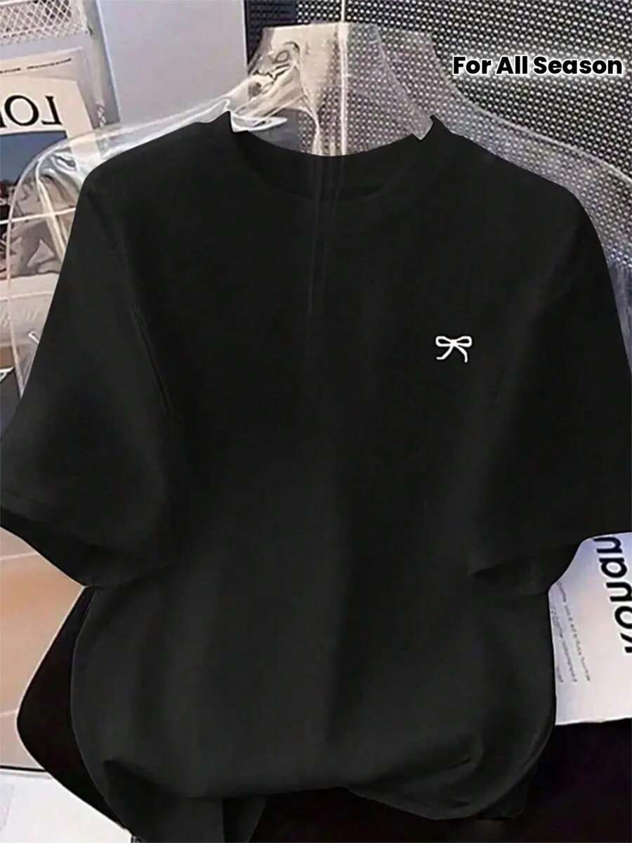 Camiseta negra de moda para todas las estaciones con detalle de lazo bordado elegante y minimalista estilo streetwear casual para hombre o mujer perfecta para combinar con cualquier atuendo urbano y lucir increíblemente chic en el día a día - Negro - Ver 1