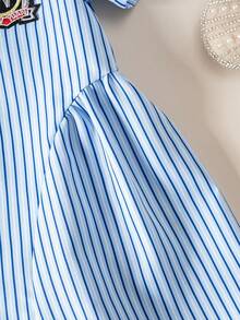 Đầm mùa hè cho bé gái kẻ sọc cổ buộc nơ dáng bất đối xứng dễ thương, kiểu dáng "preppy kẻ sọc hồng" làm cho bé gái trông đáng yêu, những đường kẻ sọc hồng trắng tinh tế tôn lên làn da trắng hồng của bé, dây đeo màu đen và họa tiết tai thỏ 3D thêu trên ngực tạo thêm nét duyên dáng và tinh tế cho chiếc đầm, một bộ trang phục ngọt ngào hoàn hảo cho bé gái. - Màu xanh lam - Xem 7