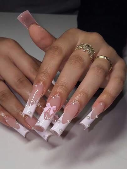 24 piezas de uñas postizas cuadradas/francesas de cobertura completa con decoración de lazo blanco tridimensional y adorno de perlas. Incluye pegamento de gelatina y tiras de frotamiento. Adecuado para agregación, reutilizable para uso diario. Su uso puede realzar su temperamento.