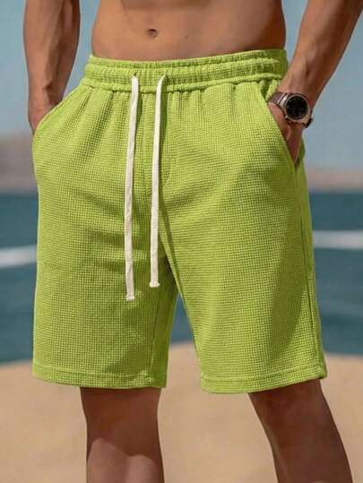 男士亮绿色沙滩短裤，格子编织纹理，华夫格纹图案，抽绳松紧腰带，透气耐穿，舒适透气，适合夏季度假穿着。
