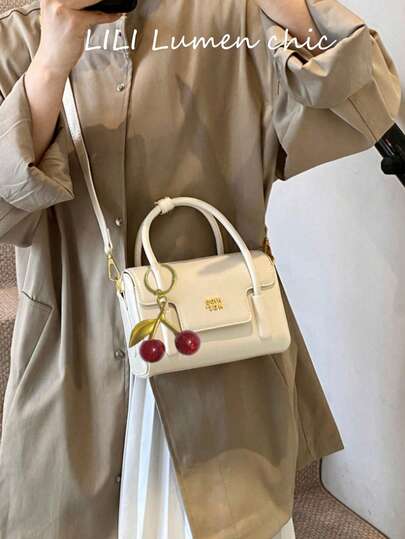 Este es un bolso novedoso y elegante con un diseño de solapa, adornado con exquisita rotulación y delicados encantos. El espacio interior puede contener llaves, lápiz labial, cosméticos y otros artículos esenciales diarios. Adecuado para diversas ocasiones, incluyendo compras, salidas, citas, viajes de negocios, viajes, fiestas y traslados diarios.