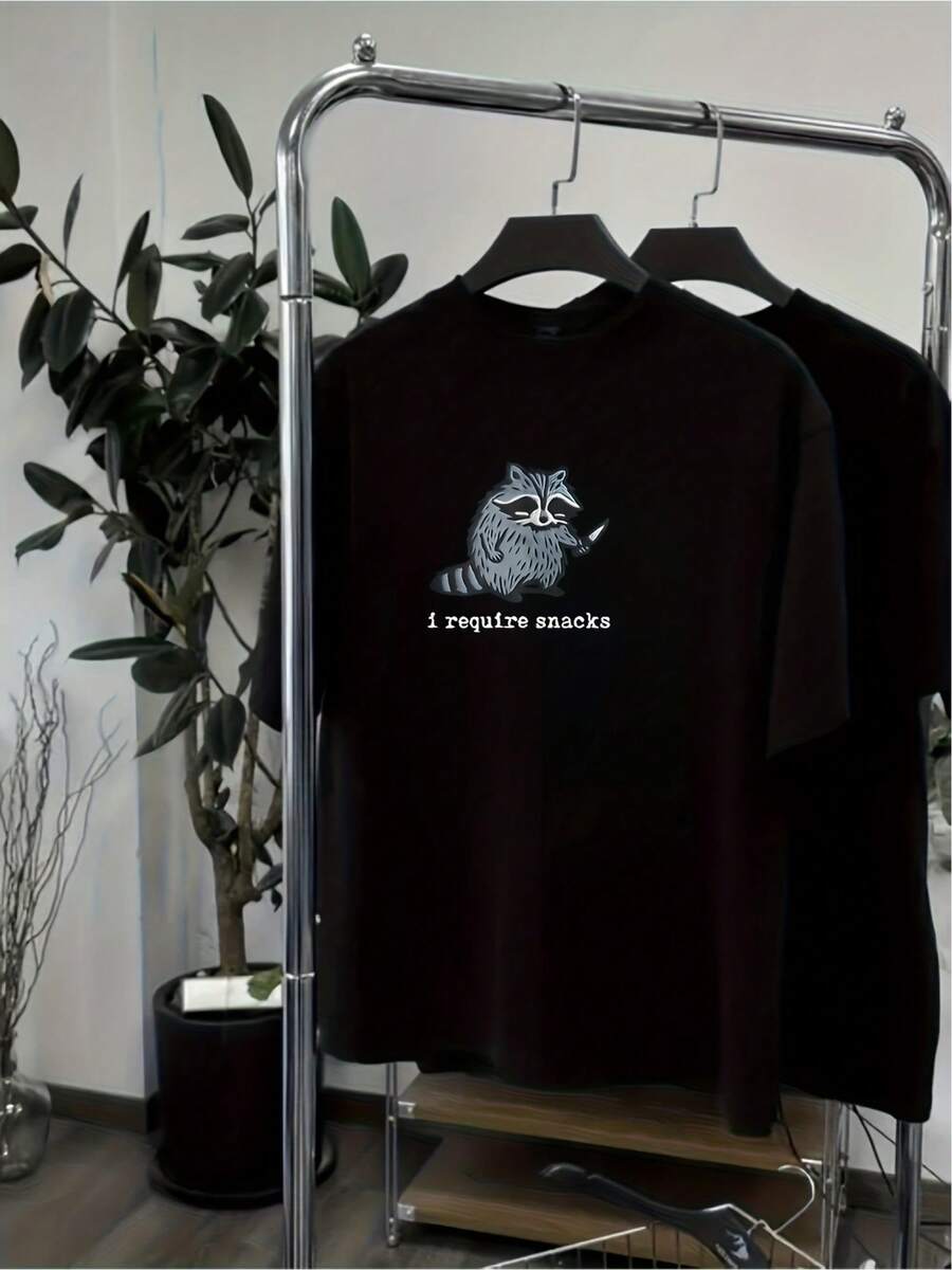 Camiseta Unisex con Estampado Divertido de Mapache Necesito Snacks Casual y Original para Amantes de los Animales Perfecta para Llevar la Cultura Pop y Estilo Urbano a las Calles Fabricada en Algodón de Alta Calidad Ideal para Regalos Cómicos y Únicos - Negro - Ver 1
