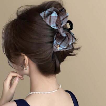 格子蝴蝶结发夹——一款时尚百搭的发饰，可轻松打造各种发型，适合丸子头、半扎发或披肩发。这款时尚发夹适合日常佩戴、上学或周末外出，以持久牢固的方式为您的造型增添经典魅力。