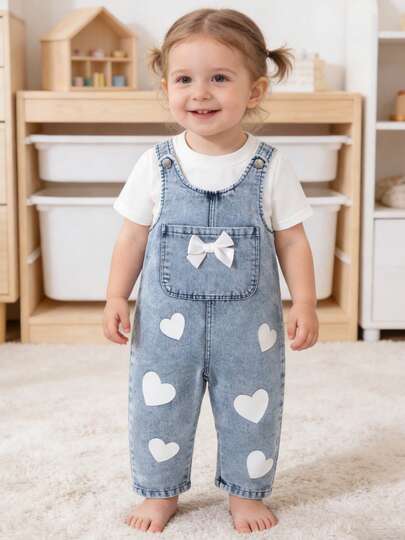 Bộ quần yếm denim cho bé gái, in hình trái tim và trang trí nơ, kiểu dáng thường ngày, thích hợp cho các hoạt động ngoài trời.