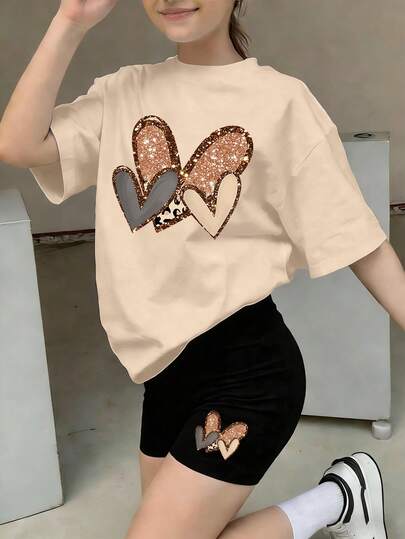 Bộ 2 món gồm áo thun ngắn tay in hình trái tim và quần short đạp xe cho bé gái, chất liệu mềm mại và thoải mái, thích hợp cho mùa xuân/hè.