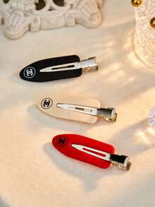 CHANEL Juego de 3 pinzas para el cabello de metal BEAUTÉ, con el logotipo clásico entrelazado CC, en rojo brillante, beige y negro - Pinza para el pelo roja, blanca y negra - Ver 7