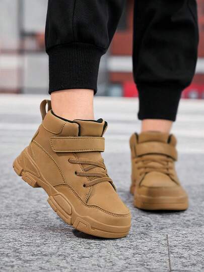 1双儿童高帮运动鞋，PU皮革材质，圆头设计，魔术贴搭扣方便穿脱，适合日常穿着和户外运动/跑步。