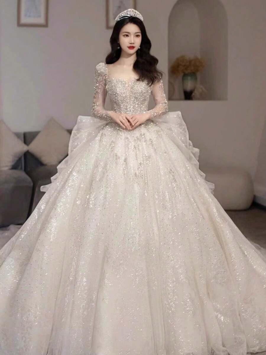 Square Neck Long Sleeve Wedding Gown With Intricate Beaded Lace Construction, Heavy Embellished Full Skirt With Luxurious Volume, Layered Mesh And Beaded Lace Fabric With Grand Visual Impact, Regal Bridal Dress Styled With Crown Accessories, Designed For Large-Scale Weddings, Cathedral Ceremonies, Church Venues, Christmas Weddings, Formal Holiday Events, Luxury Banquets, Prom Occasions And Milestone Birthday Celebrations, Perfect For Brides Who Seek Opulence, Dramatic Presence And Royal-Inspired Wedding Style - 白色 - 查看 1