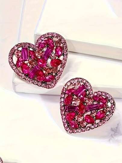 一对镶嵌水钻的奢华镂空心形耳环，简约优雅百搭的设计，适合女性佩戴。