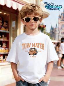 Orange "TOW MATER" Logo In Orange Lettering, Paired With A Miniature Mastiff Image And The "EST 2006" And "CARS" Logos. The Back Displays A Large Mastiff Trailer Print With A Brown Body And A Playful Expression. The Background Is Covered With Repeated "TOW MATER" Lettering, Is Topped With A Black And White Checkered Racing Flag, And Is Bottomed With A Gold Trophy And A Classic Highway Road Sign. It Can Be Paired With Cargo Shorts Or Wide-Leg Jeans And Is Suitable For Disney Racing-Themed Days, Family Road Trips, Outdoor Picnics, And School Events. - 白色 - 查看 2