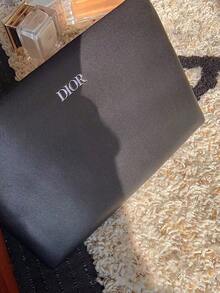 Dior 这款独特的黑色迪奥皮革手提包饰有品牌标志，尽显奢华格调。无论是出席时尚盛会还是日常使用，它都是一件必备单品。它与前卫风格和优雅服饰完美搭配，是追求高端设计的包袋爱好者的必备之选。 - 黑色 - 查看 11