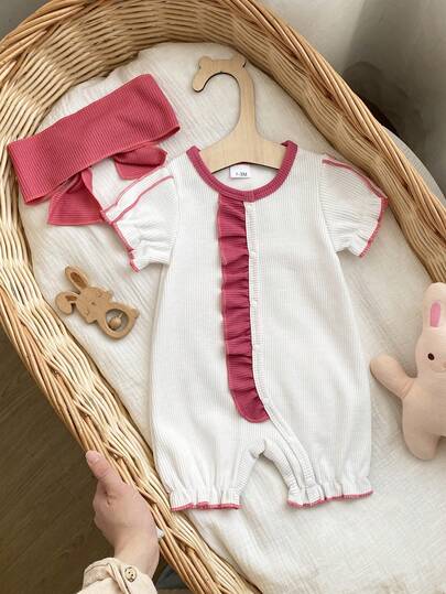 Bộ áo liền quần cho bé gái màu trắng, chất liệu vải dệt kim gân, cổ áo, cổ tay, gấu áo và nẹp áo được viền bằng đường may màu hồng tím tương phản, nẹp áo bên hông được trang trí bằng bèo nhún cùng màu, kiểu dáng ngọt ngào và dễ thương; áo liền quần tay ngắn + quần short.