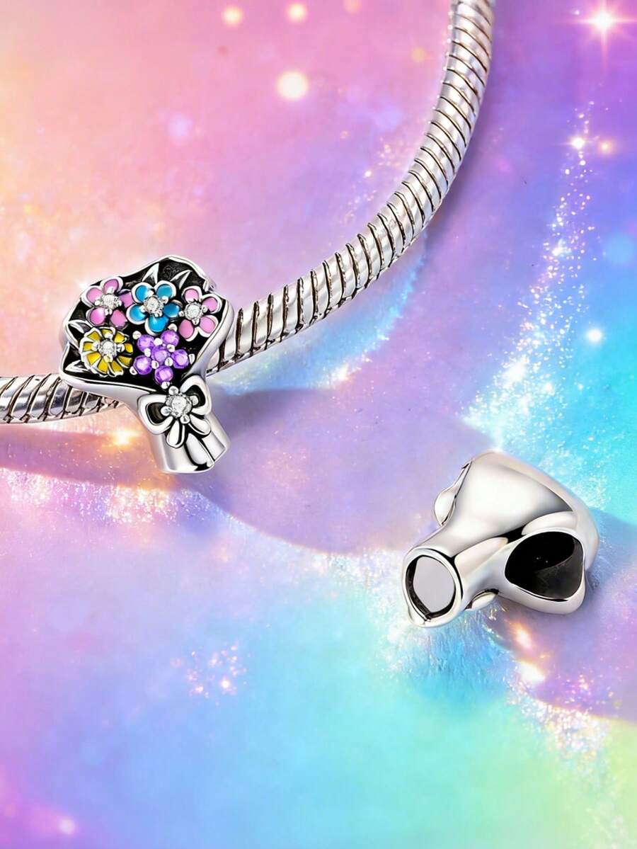 这款原创设计的银色吊坠，以其迷人的花束造型，为您的手链叠戴增添一抹亮色。吊坠上镶嵌着一排色彩鲜艳的手工立方氧化锆石，粉色、紫色、蓝色和黄色交相辉映，迷你花束设计充满活力，细节精致。