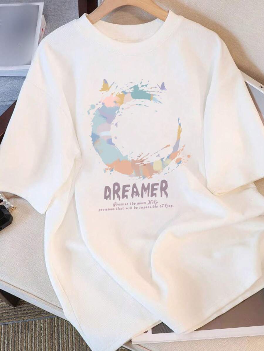 100% オーバーサイズ (ルーズフィット) DREAMER グラフィックTシャツ - パステルアクセントのカジュアルTシャツ、インスピレーションを与える引用文付き、透けない生地、洗濯機で洗えるラウンドネックトップ、カジュアルな服装に適しており、一年中快適に着用できます。