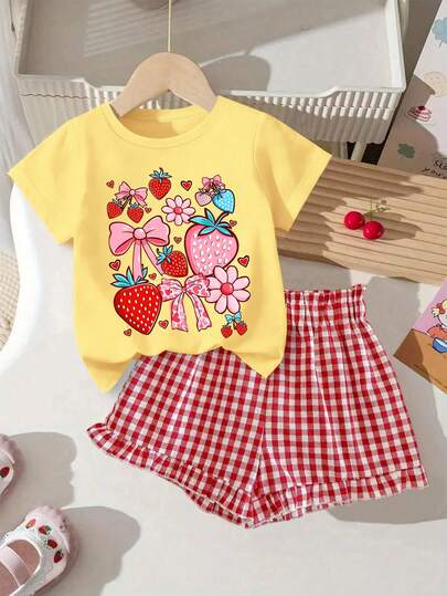 Set de 2 piezas de camiseta con estampado de lazo de fresa dulce y pantalones cortos a cuadros para niñas, camiseta suave y pantalones cortos a cuadros rojos, adecuado para uso diario en primavera/verano