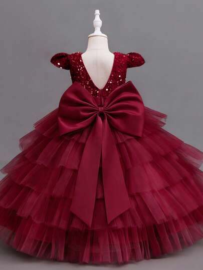 Đầm công chúa dự tiệc thanh lịch dành cho bé gái, với nơ sang trọng, cổ chữ V, đính sequin, vải voan và chân váy phồng. Thích hợp cho đám cưới, dạ hội và các dịp trang trọng.