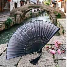 1把优雅的中式折扇，印有花卉图案并饰有流苏，适合搭配汉服、舞蹈、夏季装饰，也可作为一份精致的礼物。 - A - 查看 7