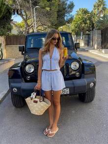 Bộ đồ đi biển mùa hè 2 món dành cho nữ: áo hai dây hở lưng kẻ sọc + áo croptop hở lưng cổ chữ V sâu buộc dây phía trước + quần short xếp ly cạp cao, kiểu dáng gợi cảm, thanh lịch và thoải mái, thích hợp cho các bữa tiệc bãi biển. - Xanh và trắng - Xem 1