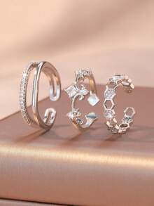 Conjunto de 3 anéis modernos e elegantes com zircônias cúbicas brilhantes em formato de coração, flor e design geométrico trançado. Design inovador, leve e luxuoso, com anéis ajustáveis. Acessórios femininos para o dia a dia, encontros e festas. - Prata - Ver 6