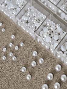 12格白色仿珍珠美甲装饰套装——包含3D和半圆形仿珍珠珠子、水钻和各种配件。这些可爱无味的“鱼子酱”仿珍珠颗粒形状和大小各异，从小到大应有尽有，是美甲爱好者的理想之选。 - 彩色 - 查看 3