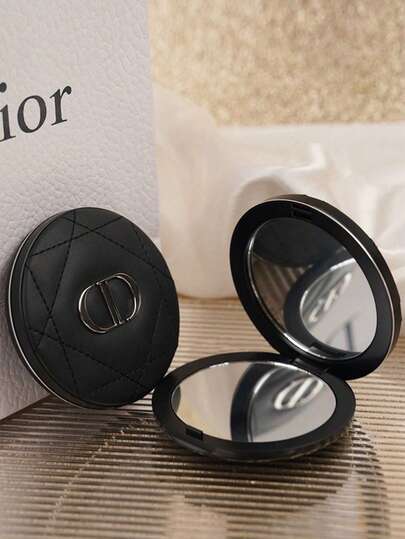 Dior 心形压纹粉饼盒，黑色外壳饰有菱形图案和银色CD标志，双面镜设计，方便补妆