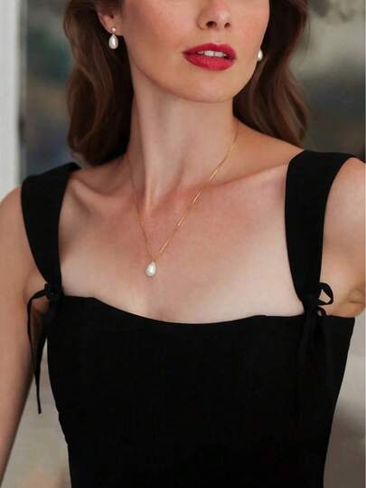 1 Bộ trang sức thanh lịch tối giản gồm dây chuyền ngọc trai giả hình giọt nước mạ vàng, quyến rũ; và bông tai ngọc trai giả hình giọt nước mạ vàng, thuần khiết lãng mạn, là trang sức cưới lý tưởng, phù hợp cho phụ nữ đeo đi dự tiệc, cũng là món quà tuyệt vời dành cho bạn bè.
