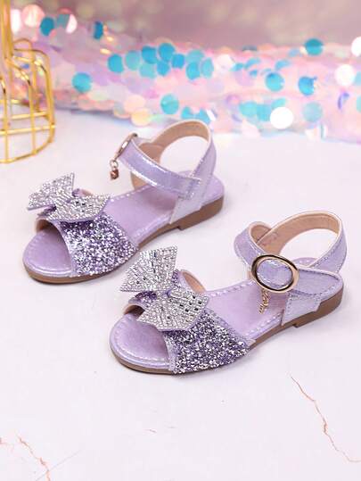 1 Đôi dép xăng đan đế bằng công chúa bướm mới cho bé gái, màu tím lấp lấp, trang trí hình bướm đính đá và ngọc trai, mặt dây chuyền tinh tế, đế mềm không gây trầy xước, có thể điều chỉnh, thích hợp cho tiệc sinh nhật, biểu diễn ở trường mẫu giáo, và mang hàng ngày.