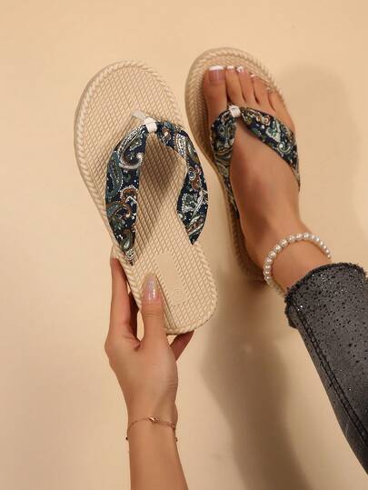 The Toe Post Is Crafted From A Lustrous Fabric Adorned With An Intricate Paisley Pattern, Artfully Interwoven In Rich Shades Of Blue, Green, And White. This Creates A Vintage Yet Opulent Aesthetic, While The Fabric's Subtle Sheen Elevates The Overall Quality. The Shoe's Silhouette Is Further Enhanced By Thoughtful Design Details, Resulting In A Style That Is Both Effortlessly Chic And Perfect For A Relaxed, Resort-Inspired Look.