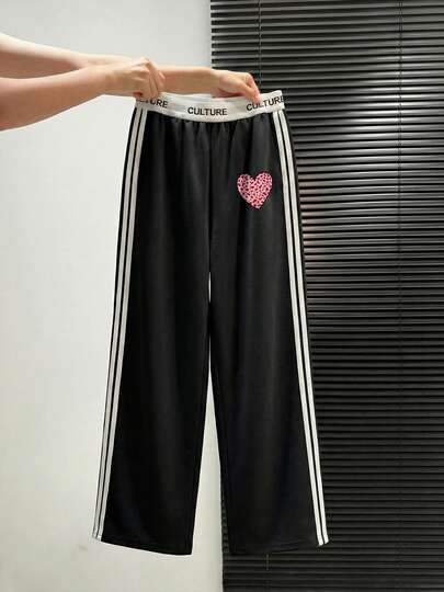 女士休闲黑色长裤，侧边饰有条纹爱心图案，采用聚酯纤维面料，可机洗，适合所有季节，阔腿直筒剪裁，饰有缎带设计，非常适合日常穿着、上学和通勤。