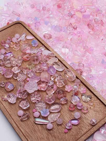 Un paquete de 50g, cuentas de vidrio surtidas de 4-25mm en formas como lágrimas, flores, estrellas, corazones, mariposas y hojas, adecuadas para varios tamaños y diseños de cuentas sueltas.